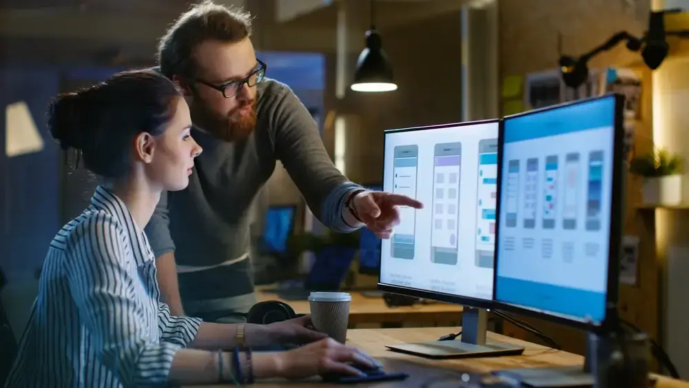 A magnifying glass hovers over a laptop screen displaying a sales graph, symbolizing a website optimization strategy