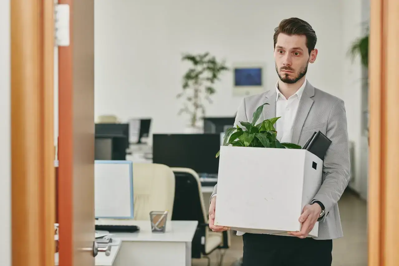 A diverse team of marketing professionals, including a CMO, collaborating in a modern open-plan office, some looking at a tablet